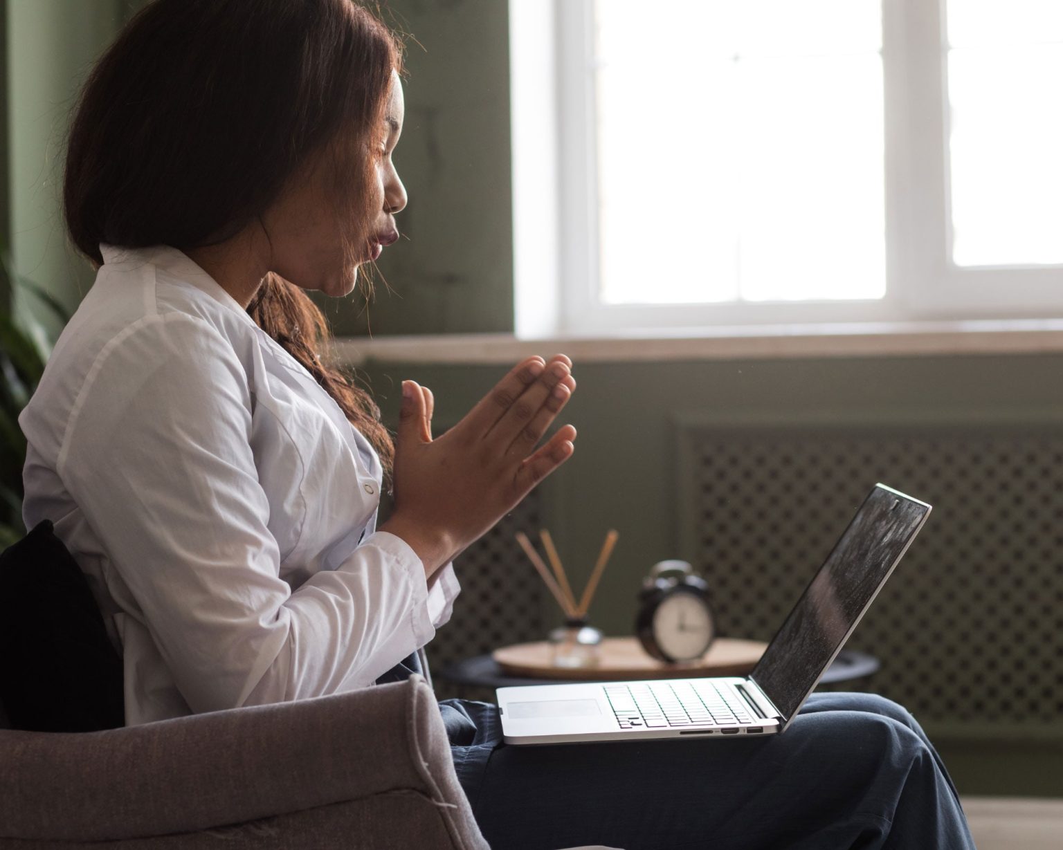 Lady talking to her Cognitive Behavioural Psychotherapist in Leicester on a laptop