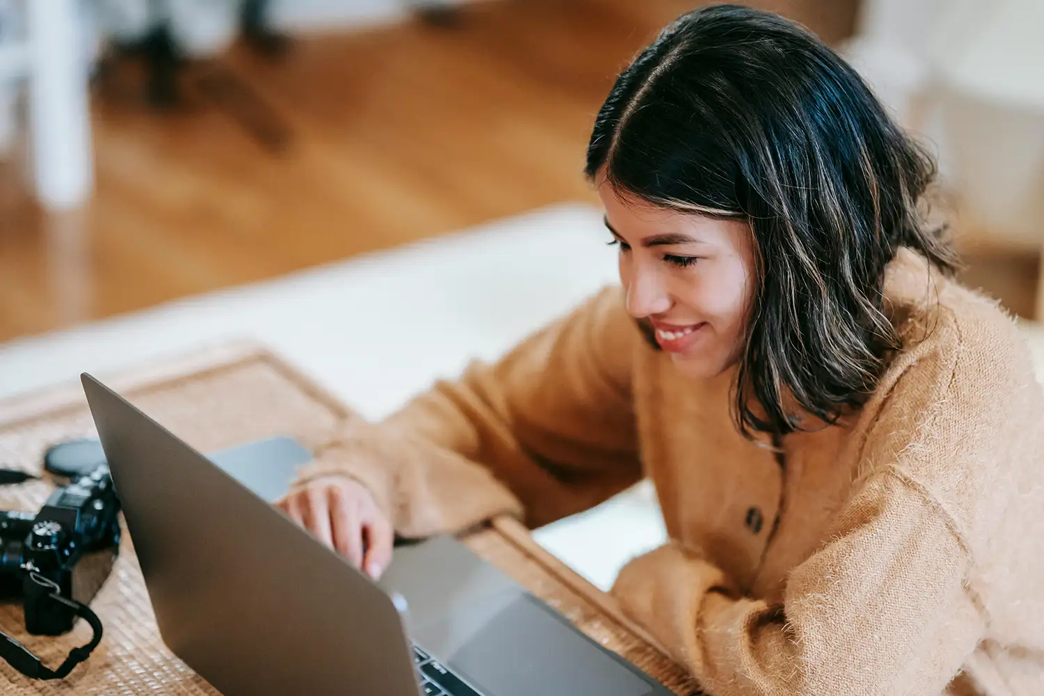 Lady with dark brown hair smiling as she talks to her psychotherapist online via her laptop